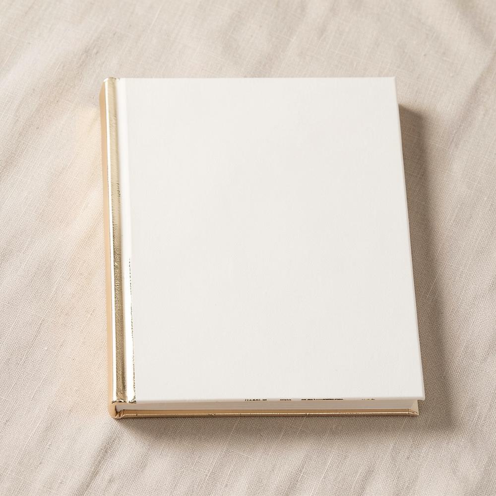 Ivory hardcover book with champagne gold foil edges on linen